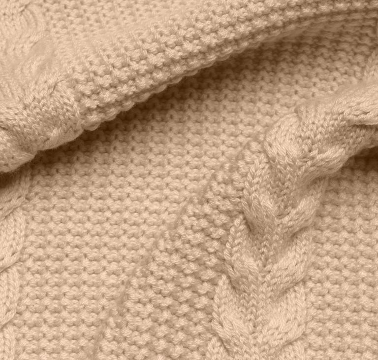 Close-up of a woven sweater with a braided pattern. 