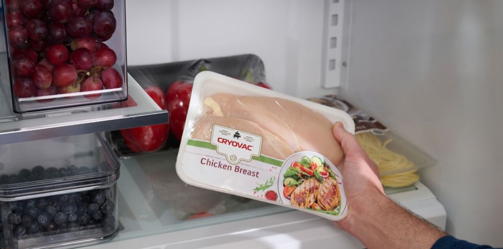 Wrapped chicken breast is seen inside a refrigerator 