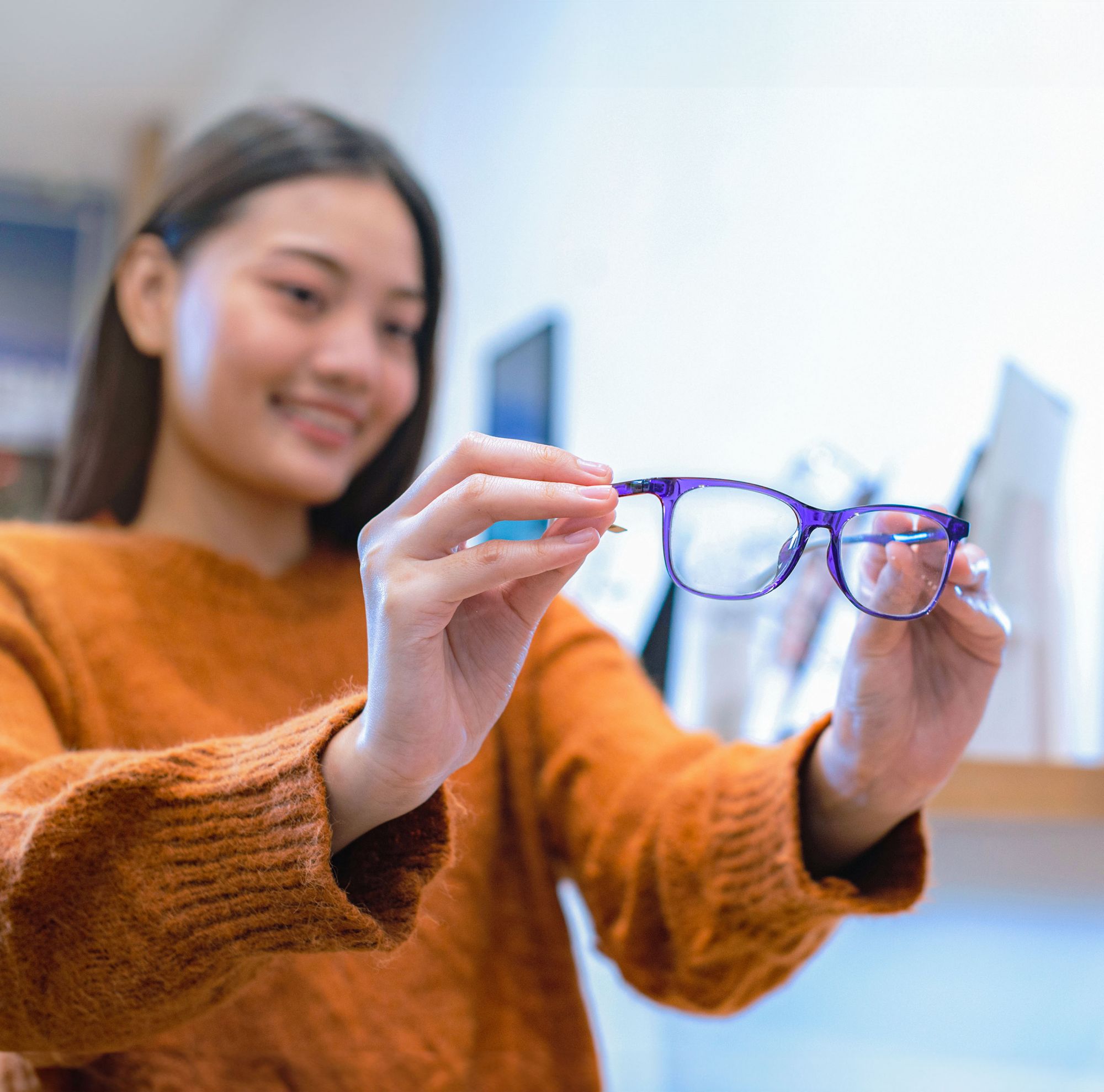 A customer inspecting glasses in a store. 